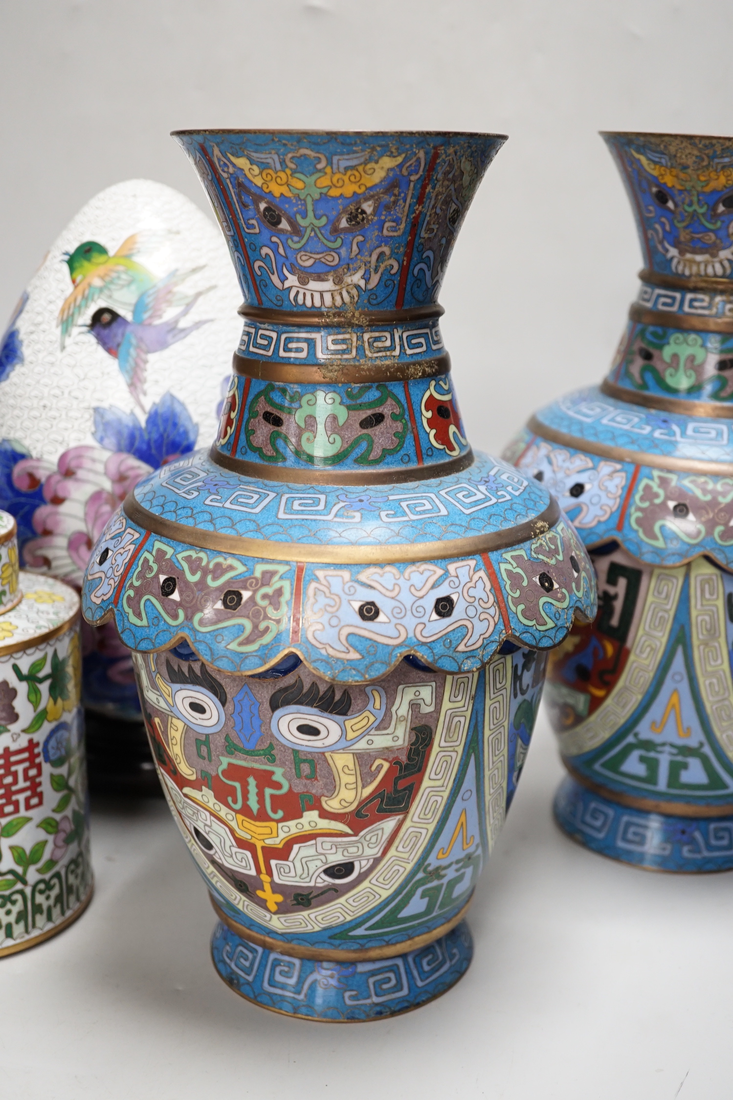 A pair of Chinese cloisonné enamel vases, a pair of canisters and covers, a large egg on stand and a small egg on stand